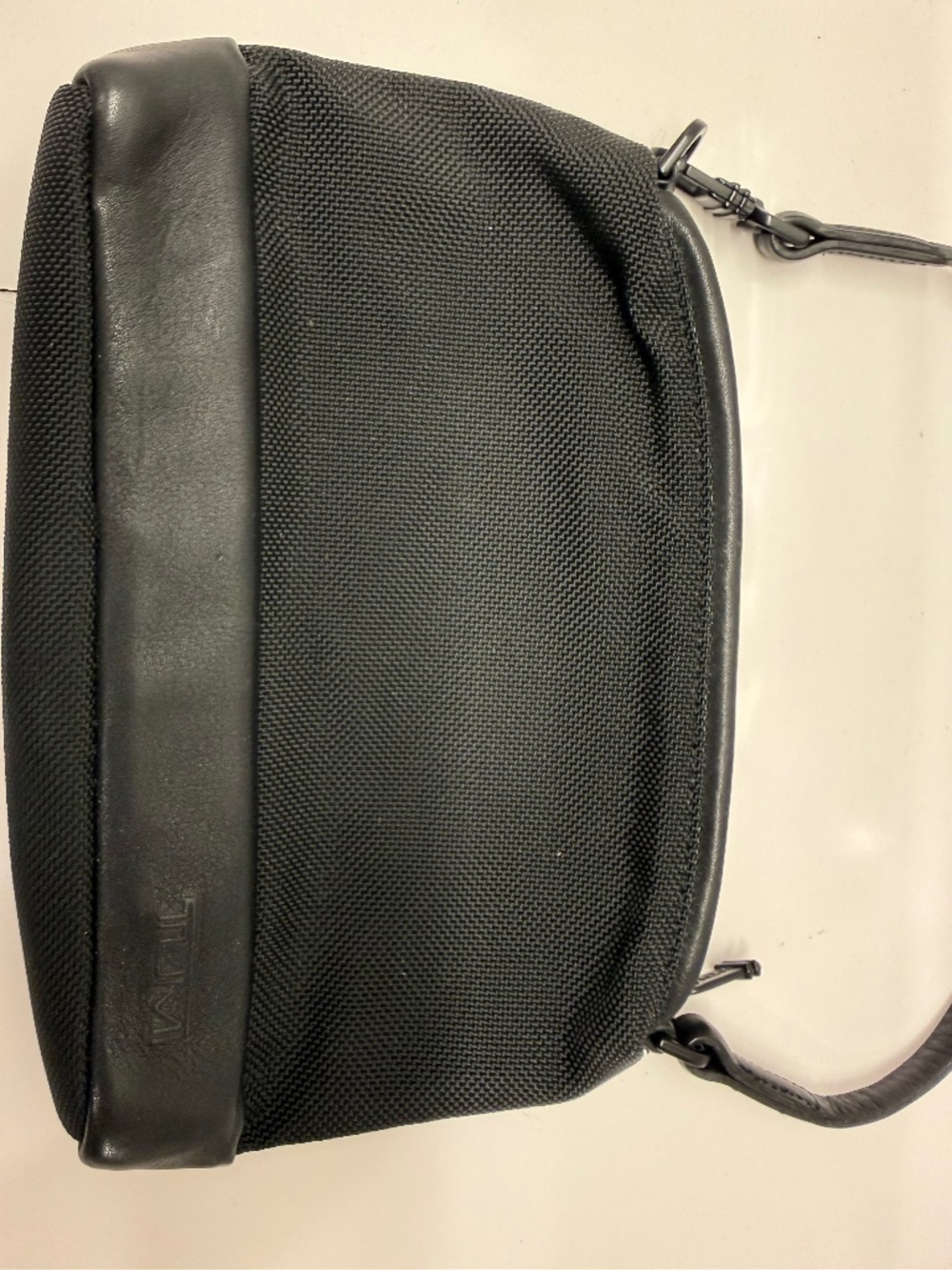 TUMI - BLACK LEATHER NYLON WRISTLET. It features a smooth leather accent.